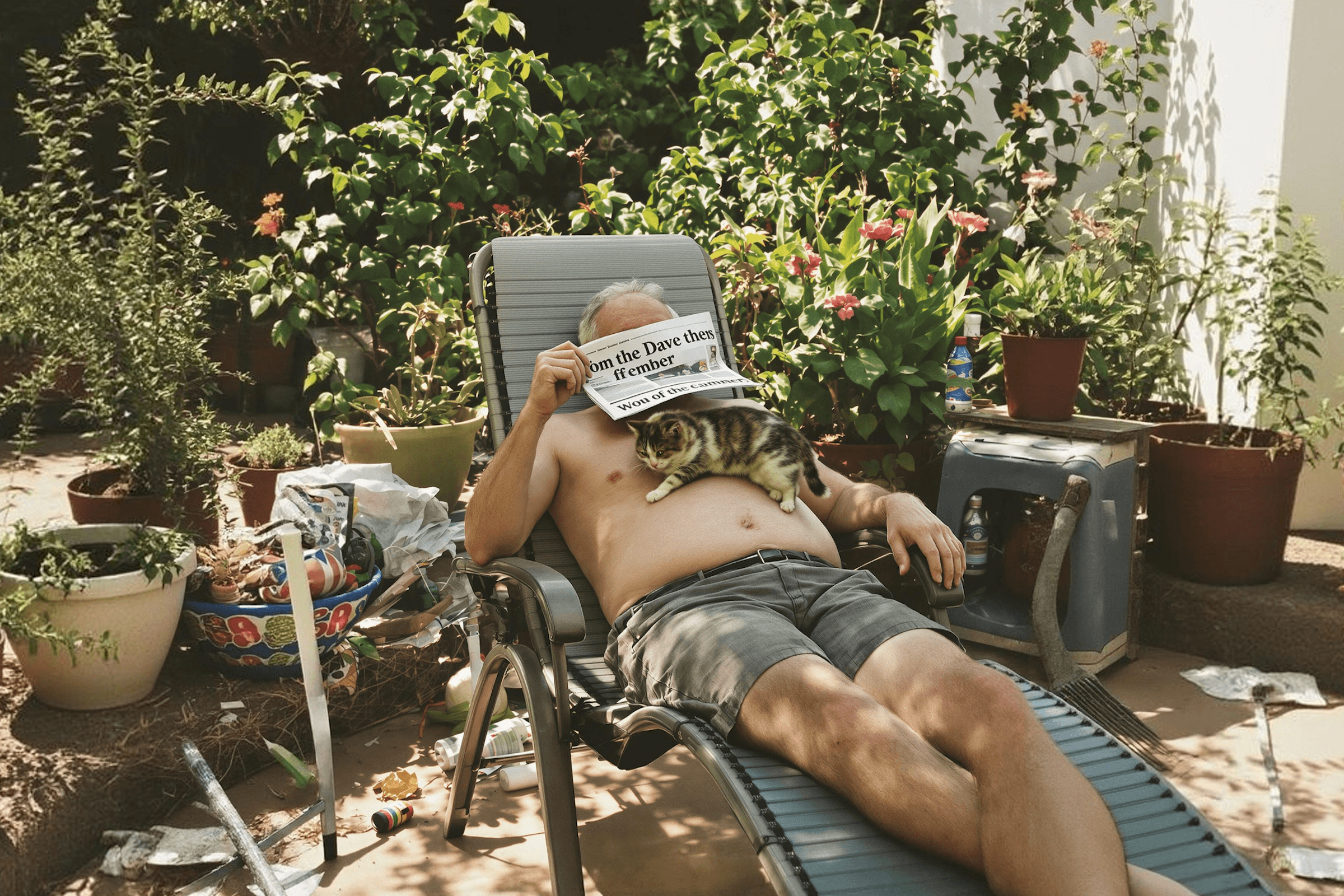 A person relaxing outdoors reading a newspaper